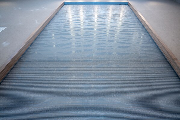 A pool with a wooden edge and a textured floor. - Holiday Inn NW Houston Beltway 8 by IHG (Houston)