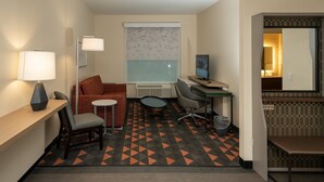 A hotel room with a desk, chair, sofa, and a computer. - Holiday Inn NW Houston Beltway 8 by IHG (Houston)