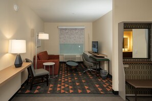 A hotel room with a desk, chair, sofa, and a computer. - Holiday Inn NW Houston Beltway 8 by IHG (Houston)