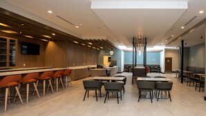A modern restaurant with a bar area, high tables, and chairs. - Holiday Inn NW Houston Beltway 8 by IHG (Houston)