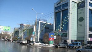 Un edificio de varios pisos con amplios ventanales y un letrero para un centro de negocios.