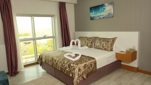 A hotel room with a large bed, a view of the city through the window, and a painting on the wall. - The City Walls Suit Hotel (Diyarbakir)