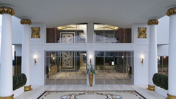 A grand entrance with a marble floor, large glass doors, and columns with golden accents. - The City Walls Suit Hotel (Diyarbakir)