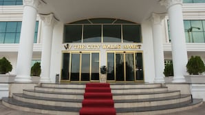 A grand entrance with a red carpet leading to a building with columns and a large glass door. - The City Walls Suit Hotel (Diyarbakir)