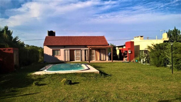 Une maison avec une piscine dans le jardin.