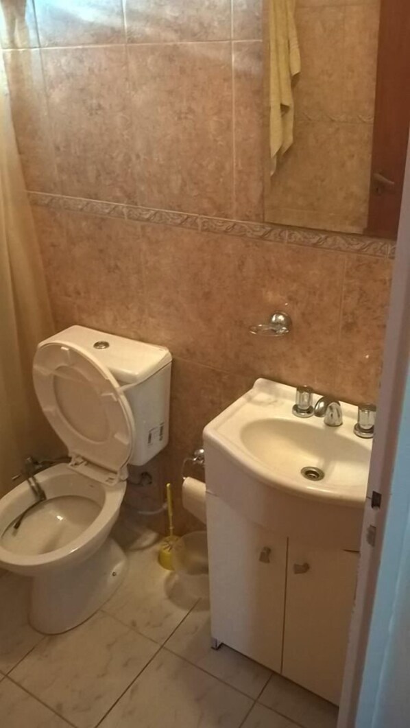 Un baño con inodoro, bidé y lavamanos.
