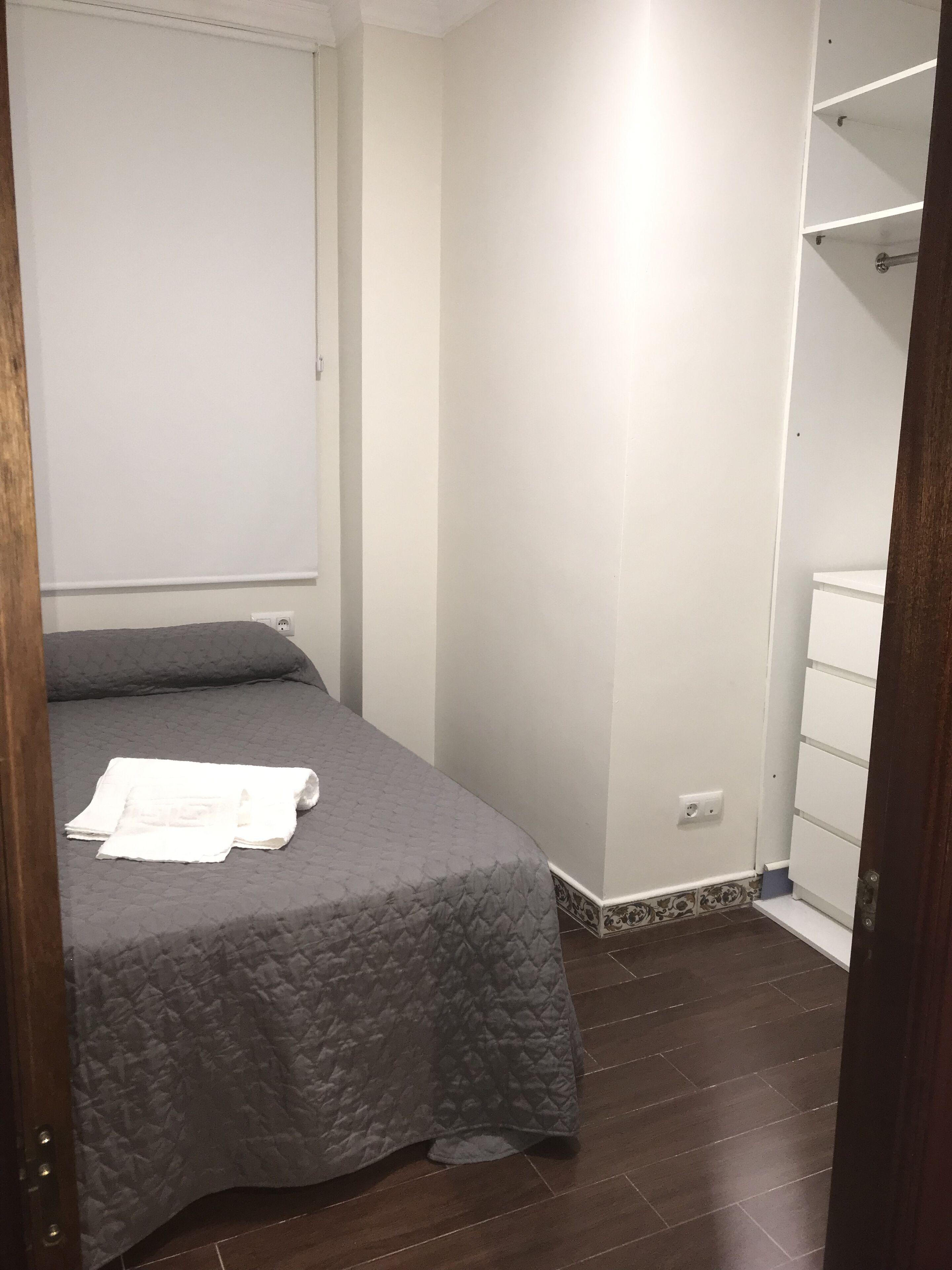 A bedroom with a bed, a wardrobe, and a door.