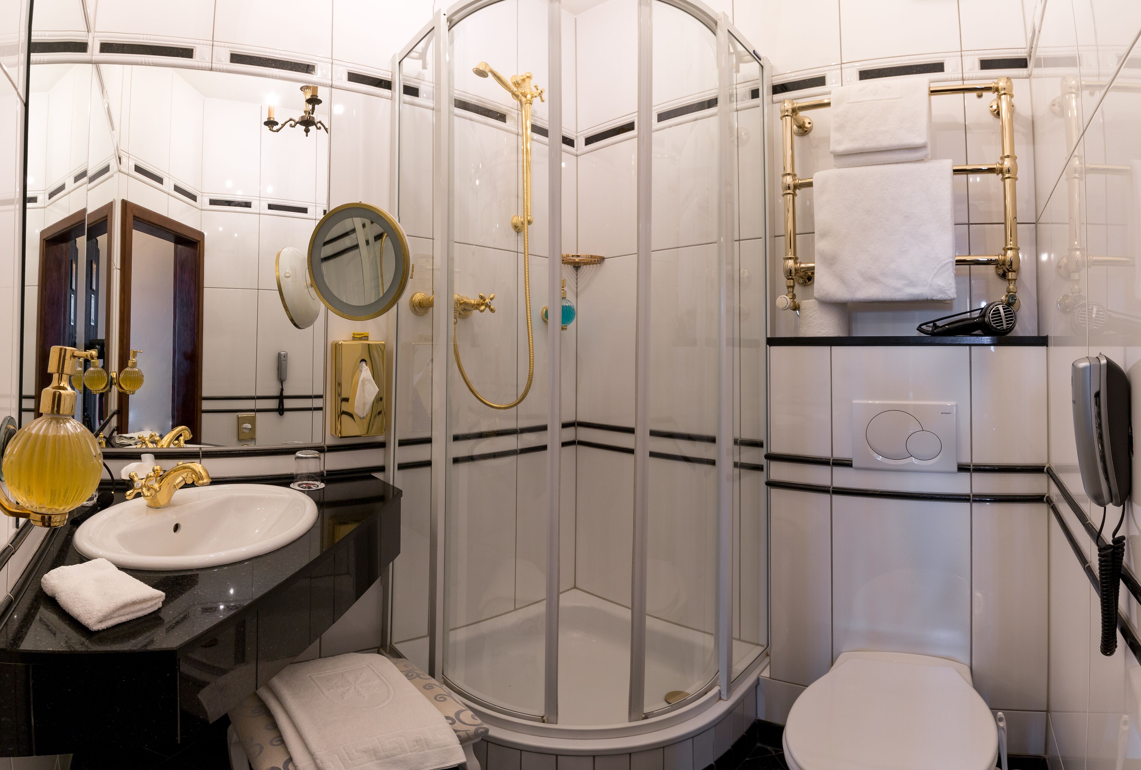 Un baño moderno con ducha acristalada, lavamanos blanco y un inodoro.