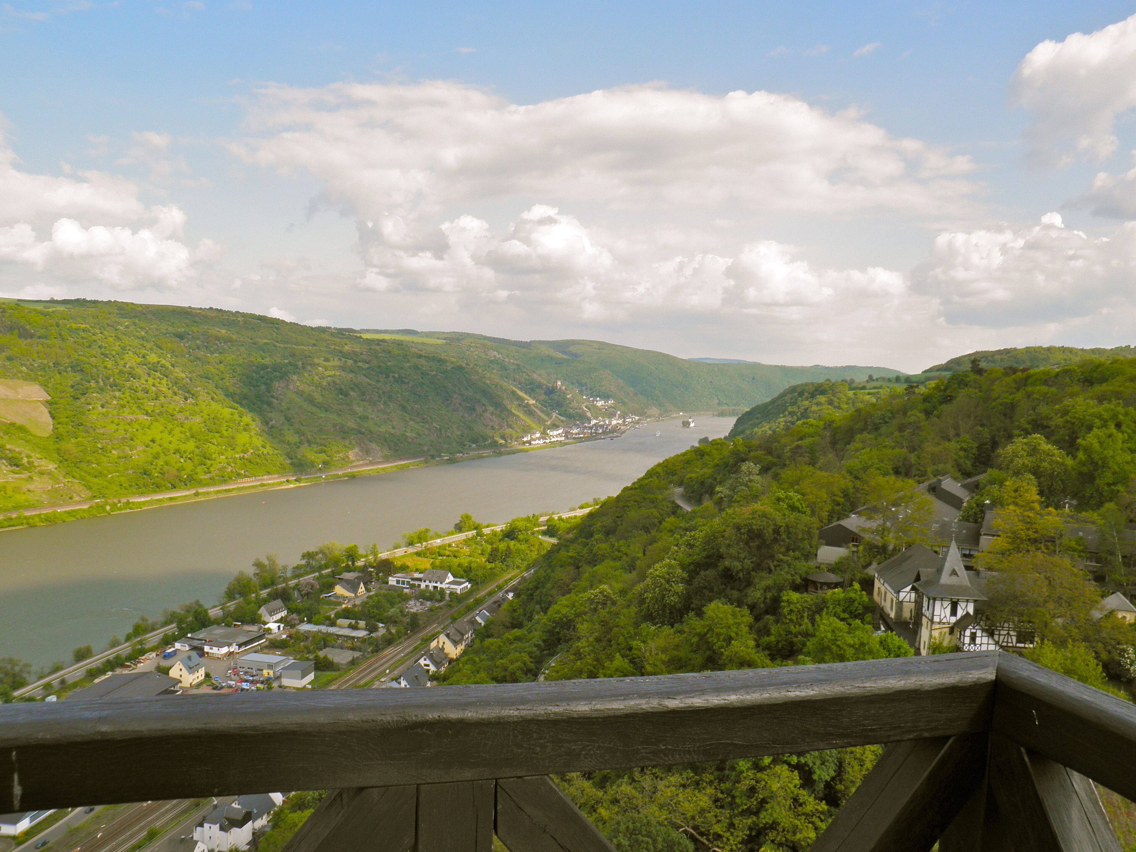 A scenic view of a river valley with lush greenery and a small town.