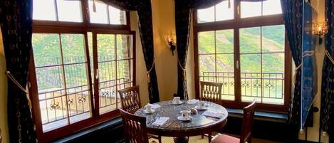 Un comedor con una mesa redonda, sillas y una araña.
