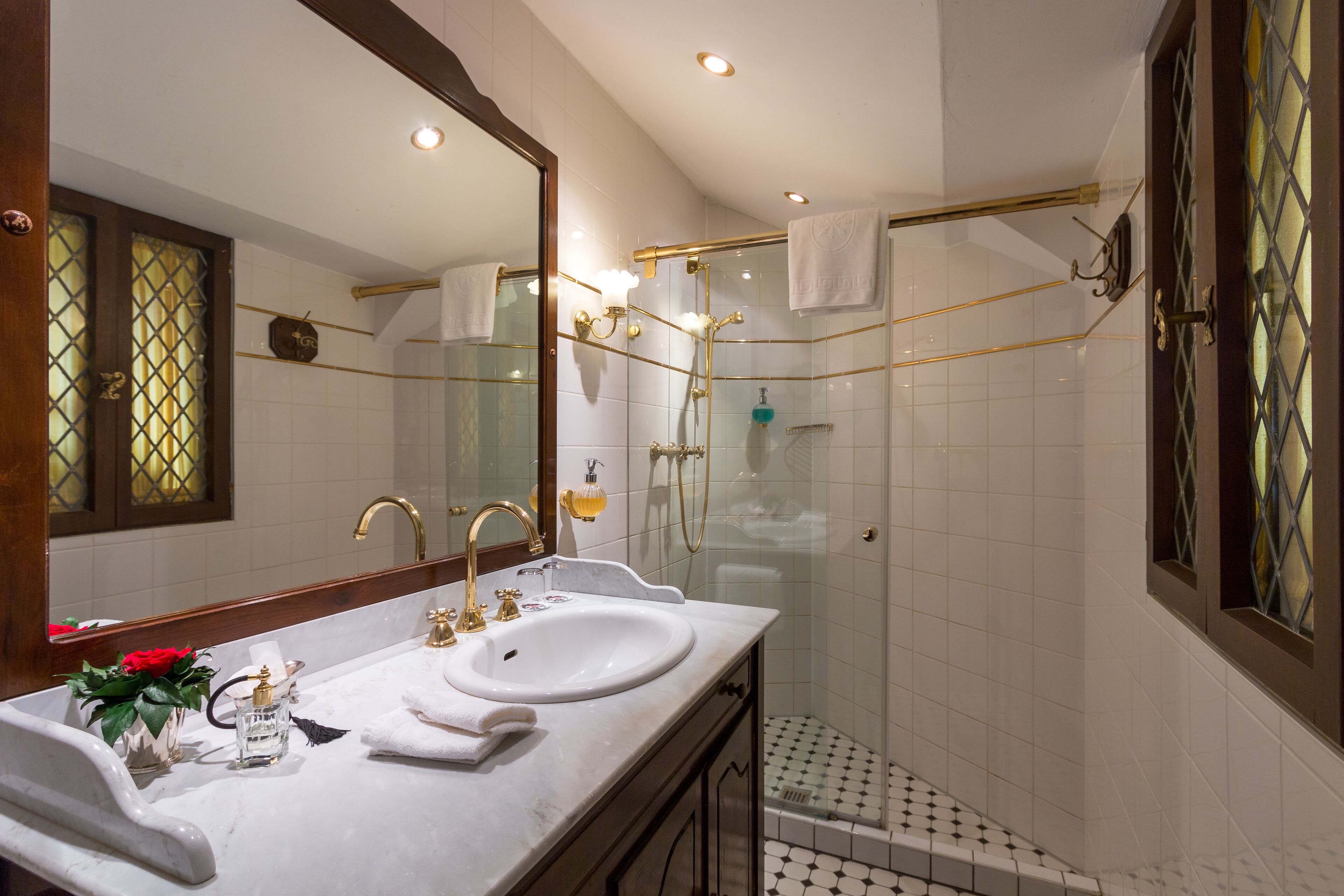 Une salle de bain avec deux lavabos, un grand miroir et un espace douche.