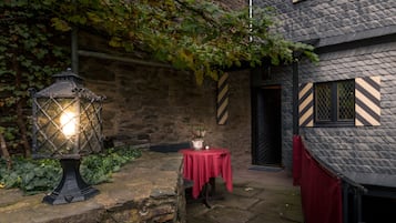 A stone building with a red table and a lantern.