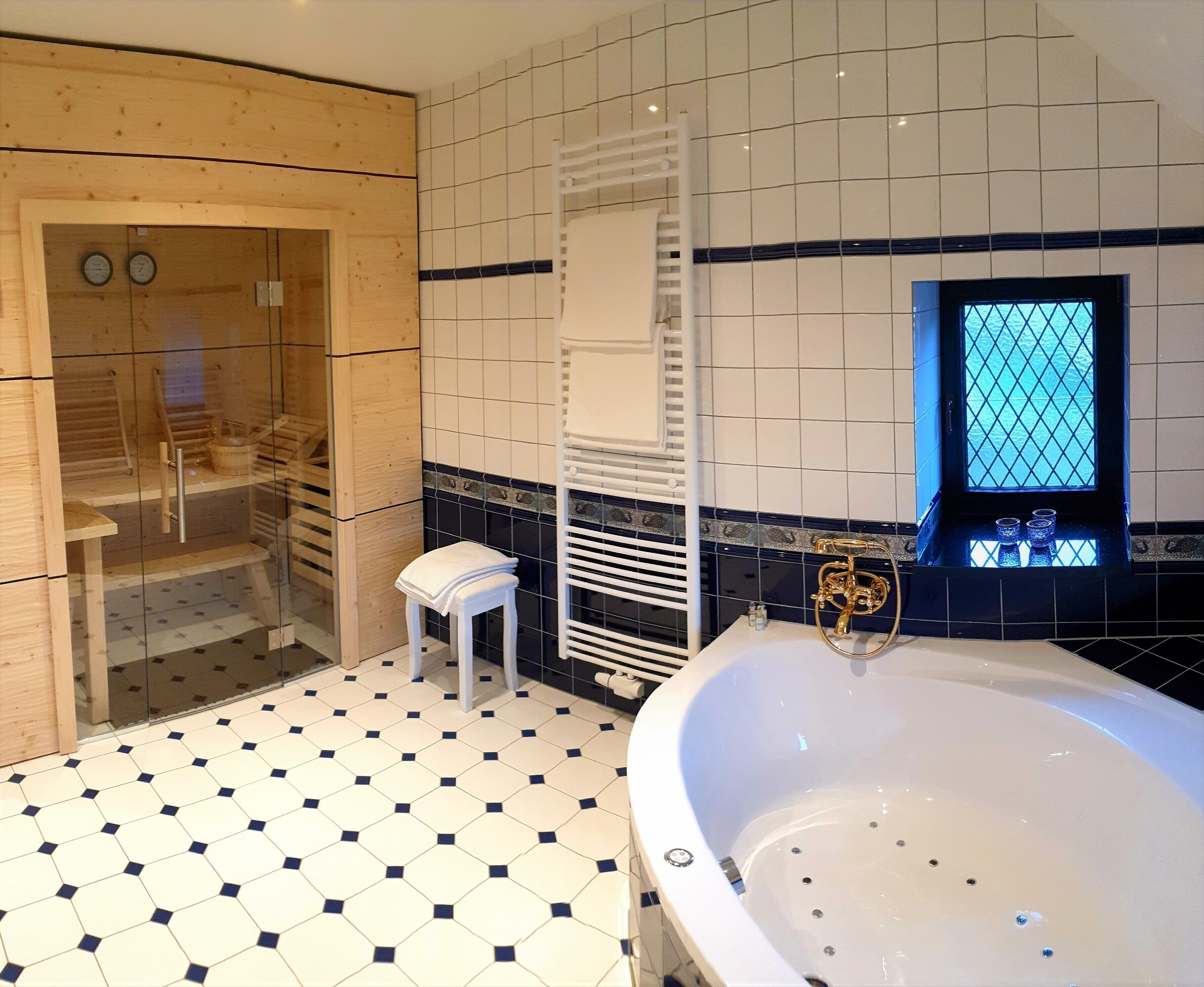 Ein Badezimmer mit einer großen Badewanne, einer Duschkabine aus Glas und einem gefliesten Boden.
