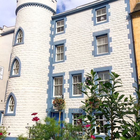 Un edificio con una torre cilíndrica y numerosas ventanas, con una decoración en azul y blanco.