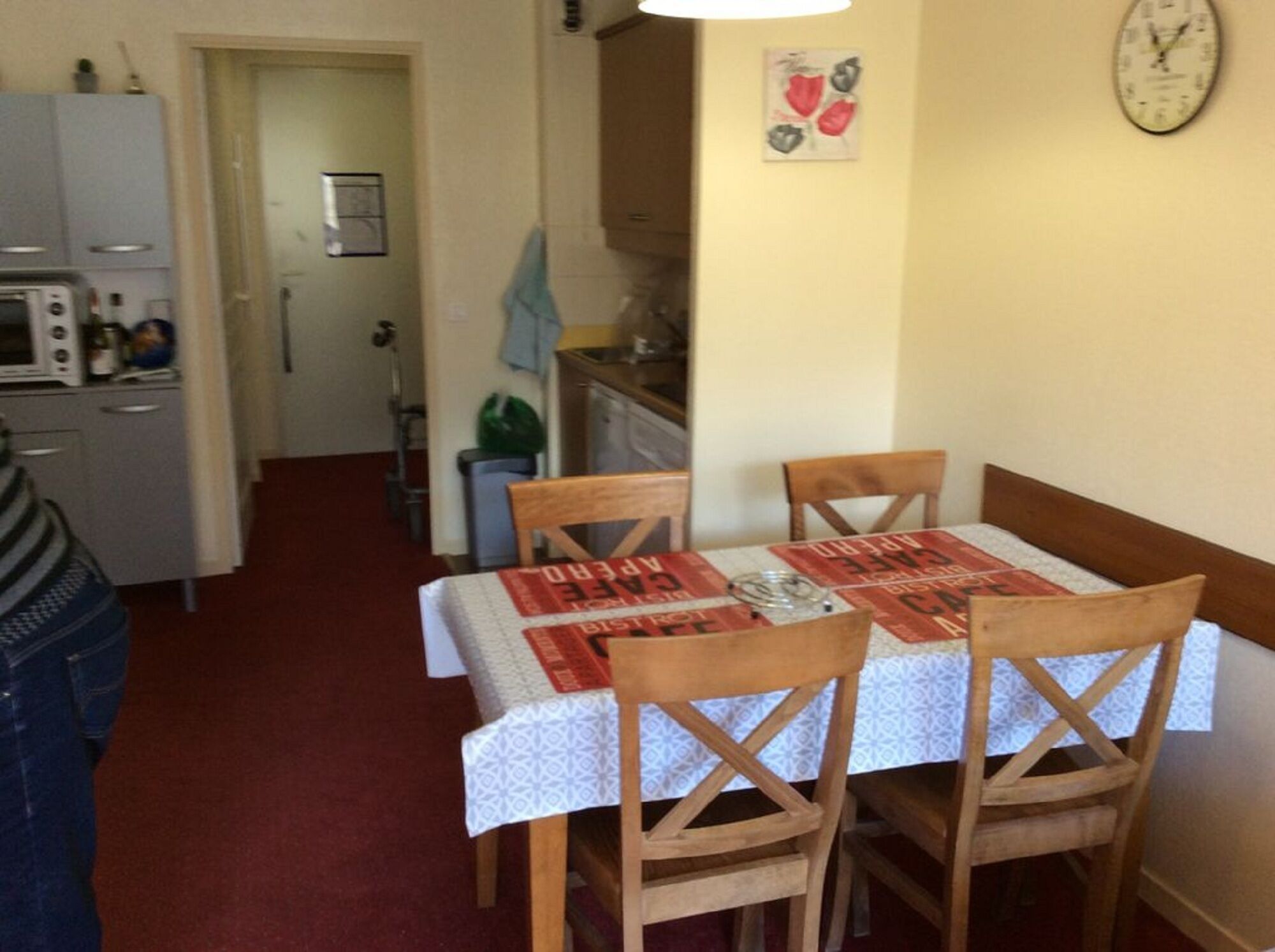 A compact kitchen with a microwave, a sink, and a dining area with a table and chairs.