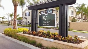Une enseigne pour le West Lucaya Villas Resort, avec une structure en forme de pergola et un jardin aménagé.