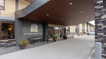 Das äußere Erscheinungsbild des Stonecroft Inn mit modernem Design, einschließlich einer überdachten Laue, einer Bank und Topfpflanzen.