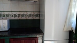 Eine Küche mit einem weißen Kühlschrank, einer Mikrowelle und einem Herd.