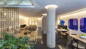 Un interior moderno con comedor, sala de estar con sofá y una imponente estructura de columna.