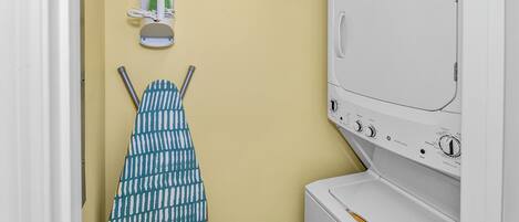 A laundry area with a washing machine, an iron, and a drying rack.