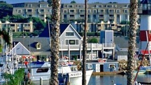 A marina with boats, a sign for Oceanside Harbor, and a row of buildings in the background. - Spacious Oceanside Executive Home Close  to beach (Oceanside)