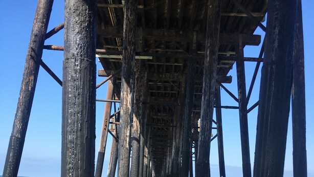 A pier with wooden beams and columns extending into the water. - Spacious Oceanside Executive Home Close  to beach (Oceanside)