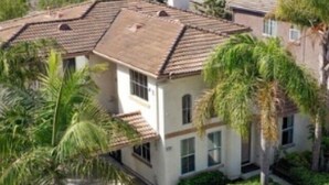 A two-story house with a tiled roof, surrounded by palm trees and a well-maintained lawn. - Spacious Oceanside Executive Home Close  to beach (Oceanside)
