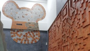 A staircase with a unique wall art design on the left and a geometric brick pattern on the right. - Hoftors (Bangkok)