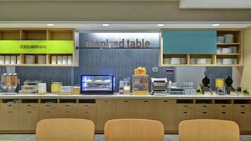 A modern breakfast bar with a 'Good Morning' sign, a display case, and a 'Inspired Table' sign.