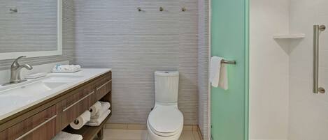 Un baño moderno con lavamanos, tocador, inodoro y ducha.