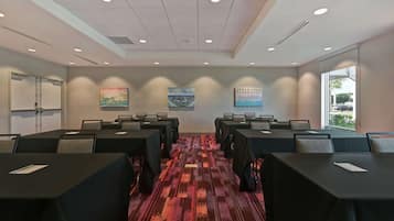 A conference room with tables, chairs, and artwork on the walls.