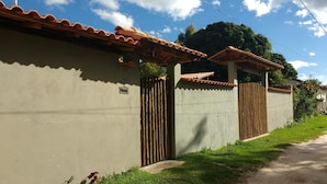 Una casa con el número 199 en la pared, techo de tejas y valla de madera.