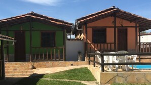 Una propiedad con dos edificios separados, una piscina y un césped bien cuidado.