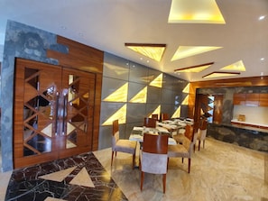 Enjoy meals in this stylish dining area with a dining table and chairs, surrounded by geometric patterns and illuminated panels.