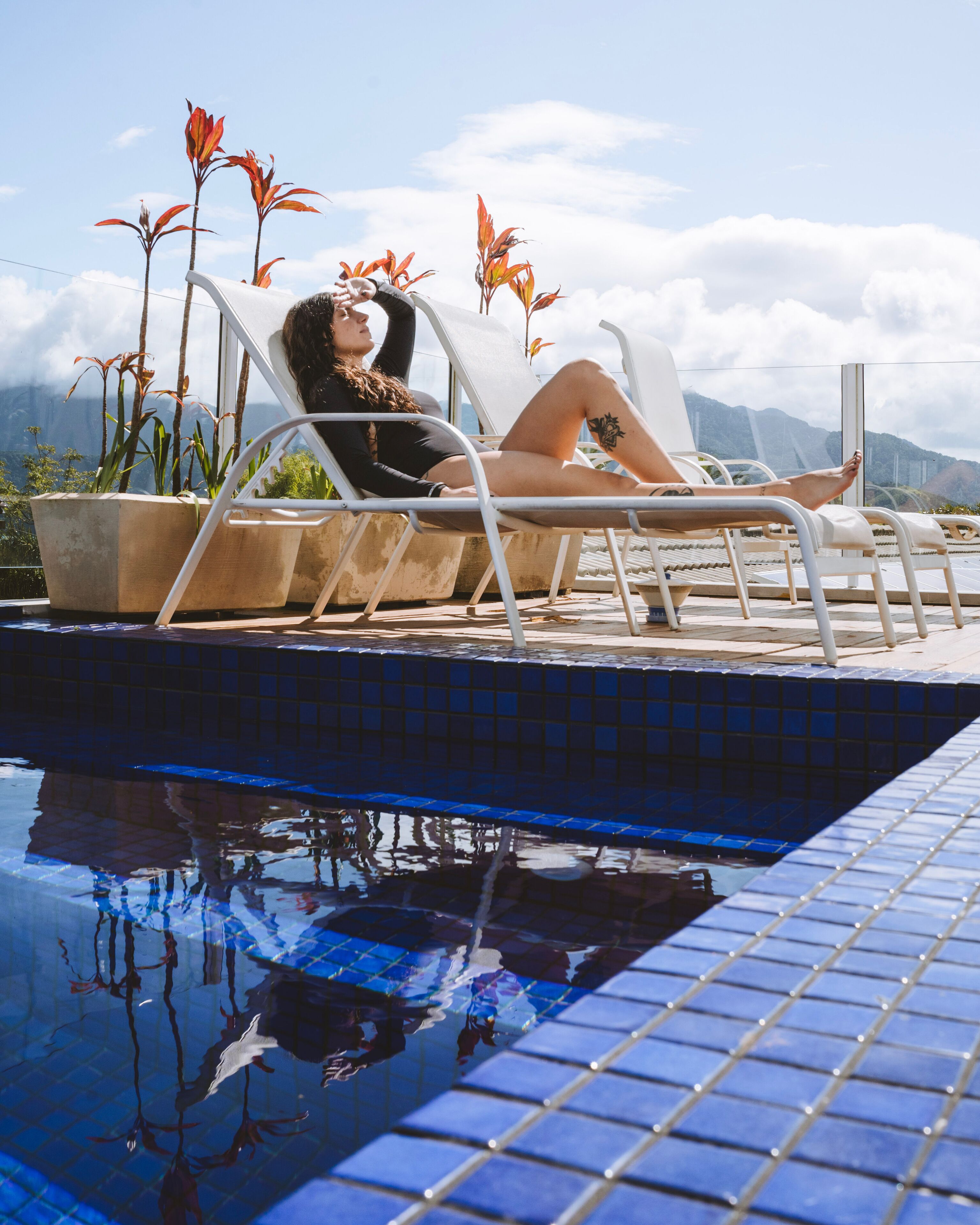 A poolside area with lounge chairs and potted plants.