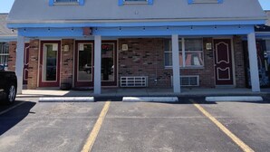 A two-story building with a flat roof, a brick facade, and a covered front porch. - Travel Inn Delaware (Delaware)