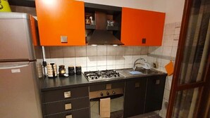 Uma cozinha compacta com fogão a gás, forno e pia.