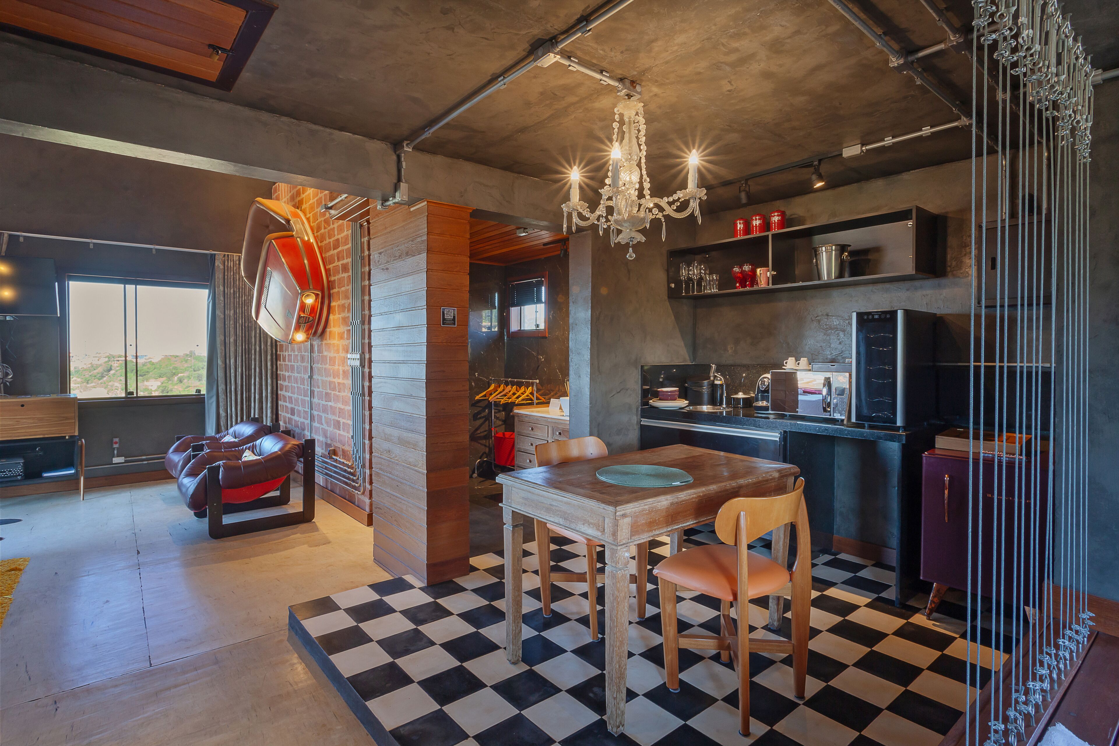 A modern kitchen with a checkered floor, a dining table, and a chandelier.