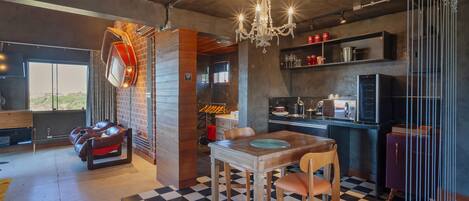 A modern kitchen with a checkered floor, a dining table, and a chandelier.