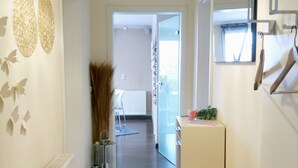 A hallway with a chandelier, radiator, and a small bench. - Feel-good time in the Zittau Mountains (Eichgraben)