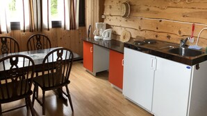 Una cucina in stile baita con tavolo e sedie, una macchina del caffè e un lavello.