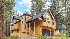 A large, multi-story log cabin with a prominent front porch and a garage. - Sugar Pine Lodge: Hot Tub, Large Yard, Games (South Lake Tahoe)