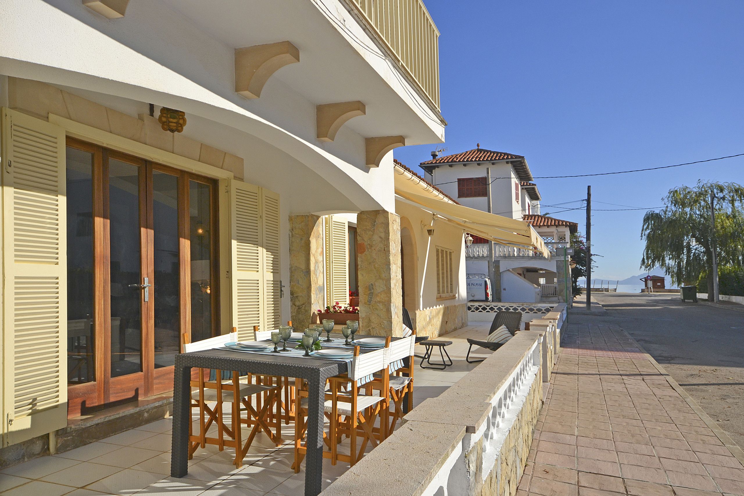 Un restaurant en bord de mer avec une terrasse et des places assises en plein air, offrant une vue sur la mer.