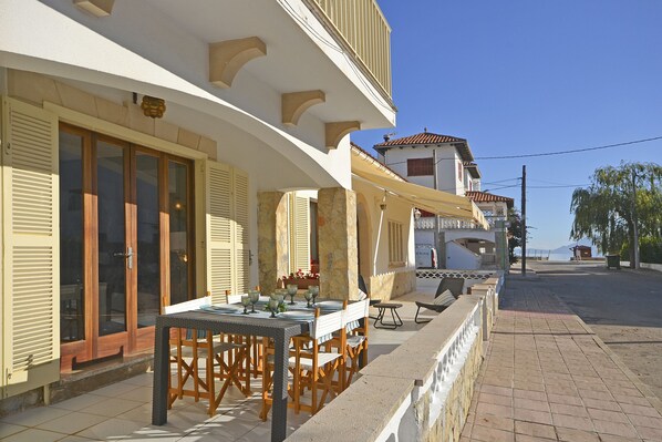 A seaside restaurant with outdoor seating, a terrace, and a view of the sea.