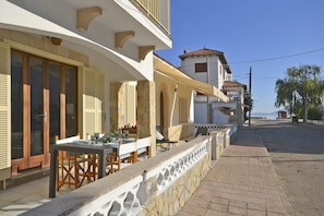 A seaside property with a dining area, outdoor seating, and a view of the sea.