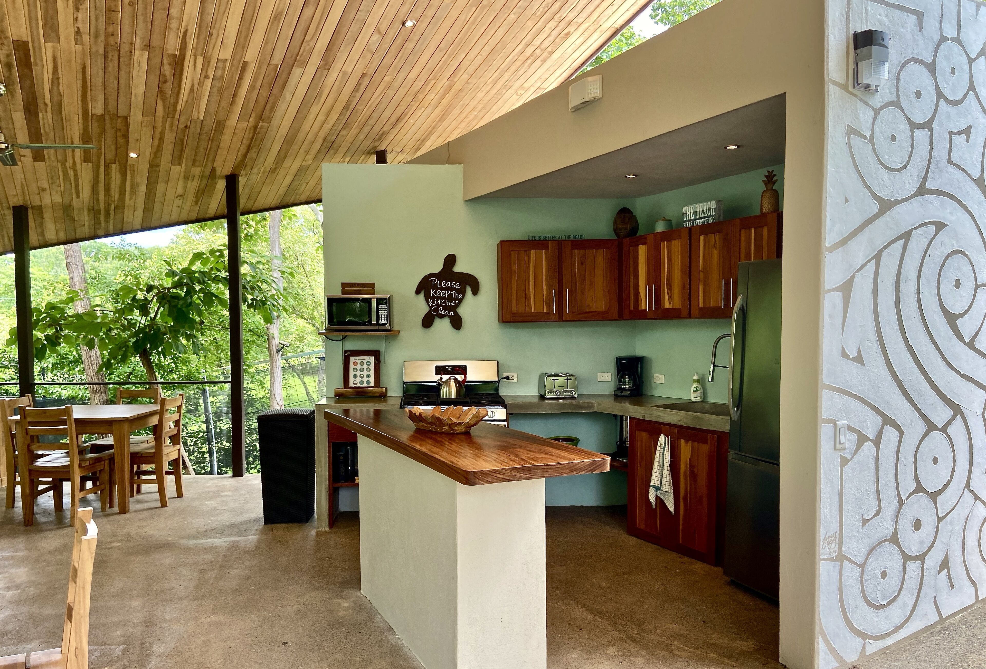 A kitchen with wooden cabinets, a central island, and a microwave.