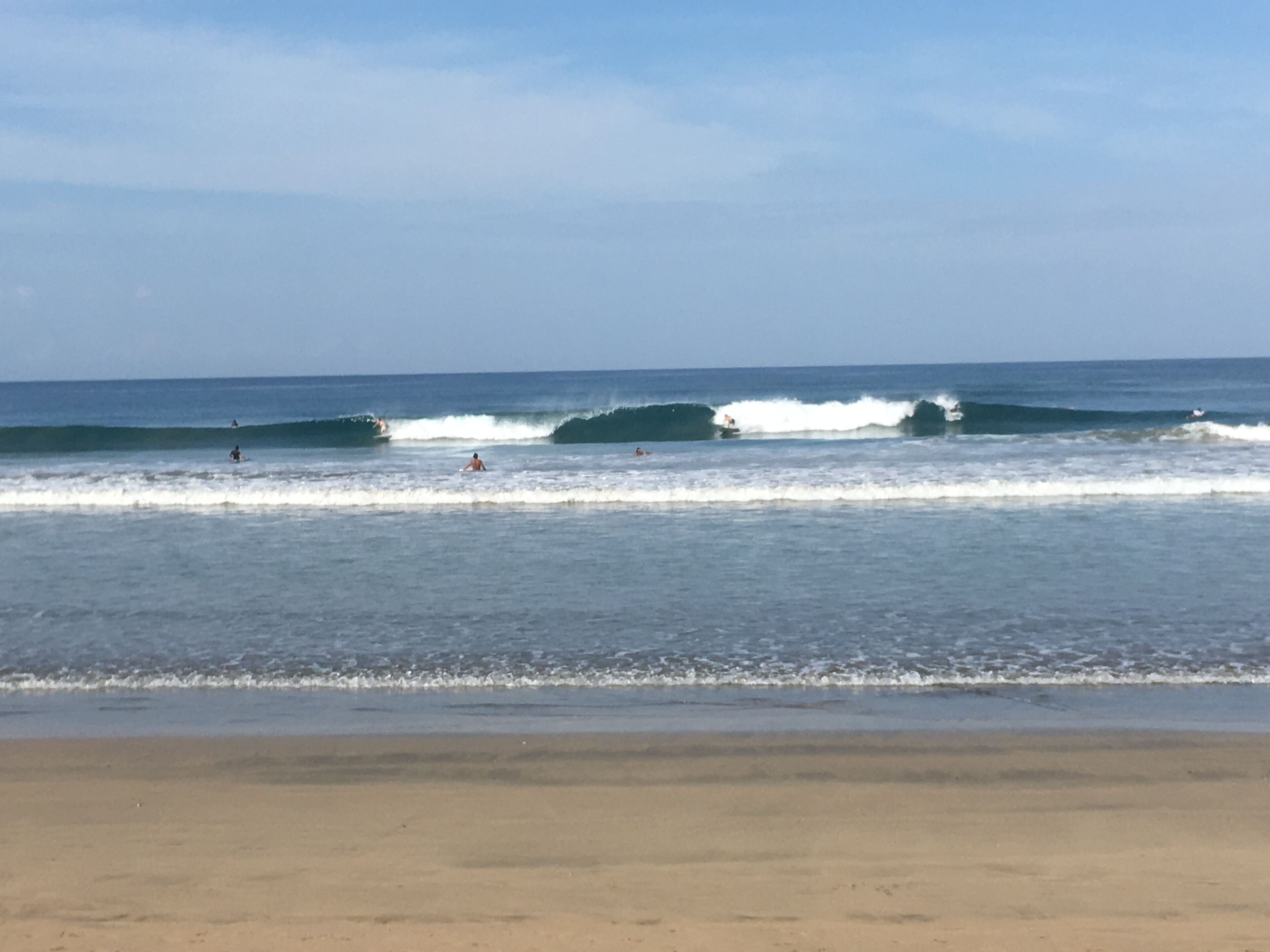 Una playa con olas y surfistas.