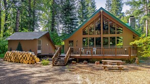 Une cabane dotée d’une terrasse en bois, d’un escalier et d’une table de pique-nique.