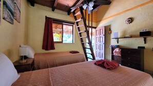 Una habitación con dos camas, una escalera, una ventana con cortinas, un escritorio con lámpara y un estante con objetos.