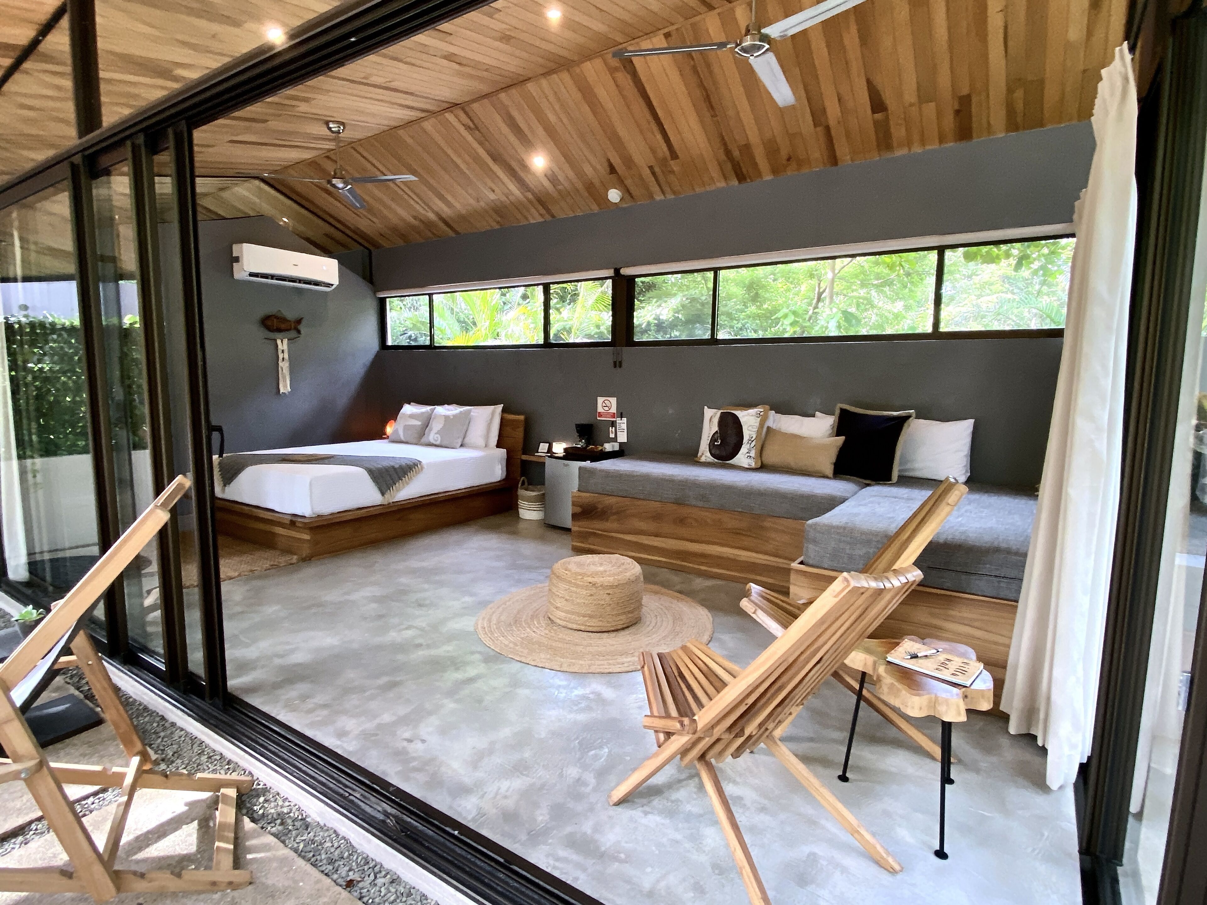 A modern room with a bed, sofa, and a small table with a hat.